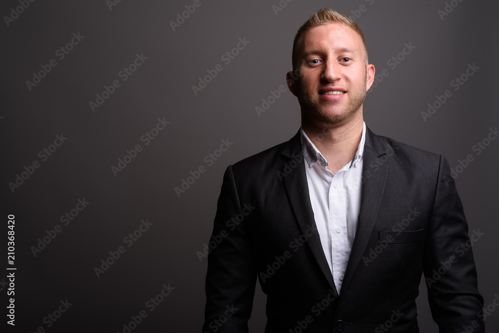 Businessman with blond hair against gray background Businessman with blond hair against gray background
