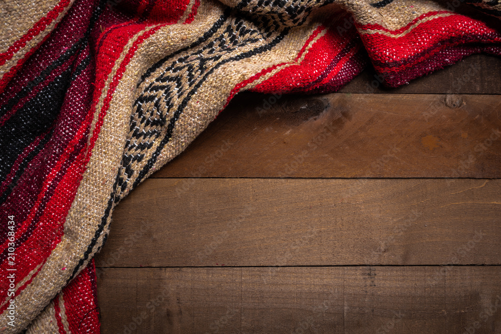 A mexican serape blanket on a wooden plank background - obrazy, fototapety, plakaty 