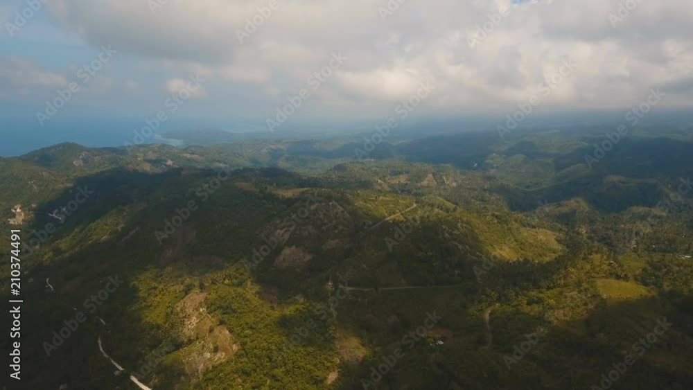 Mountains with rainforest covered with green vegetation and trees on the tropical island, landscape. Aerial view: Mountains and hills with wild forest, sky clouds. Hillside rainforest and jungle Mountains with rainforest covered with green vegetation and trees on the tropical island, landscape. Aerial view: Mountains and hills with wild forest, sky clouds. Hillside rainforest and jungle