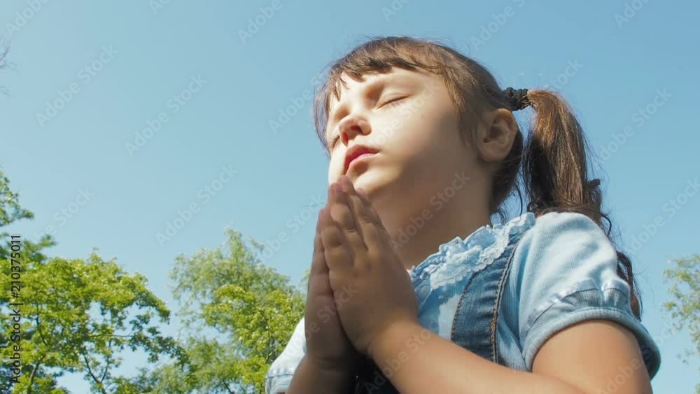 The child prays. Little girl prays in nature. The child prays. Little girl prays in nature.
