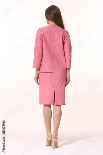 young caucasian business woman executive posing in pink skirt official suit high heels stiletto shoes full body length isolated on white back view