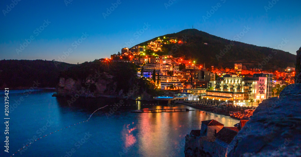 View on illuminated coastline and old town at night in Budva, Montenegro