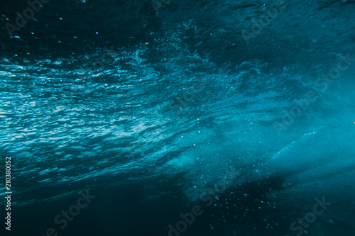 Underwater barrel wave and surfer in tropical sea in Oahu.