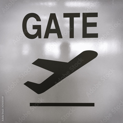 Picture of sign with an airplane taking off for the direction of the departure terminal at an airport