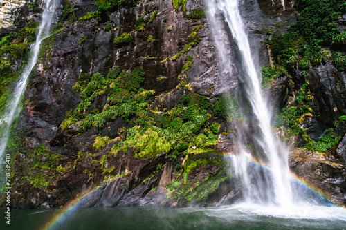 Fototapeta Naklejka Na Ścianę i Meble -  A stunning scene under waterfalls while cruising at Milford Sound, New Zealand.