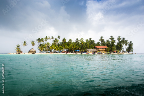 A small Caribbean island. Clear water and blue sky can be seen.