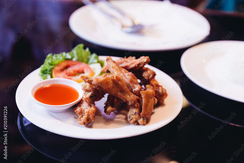 Fried chicken wings with salt served with chili sauce. Fried chicken wings with salt served with chili sauce.