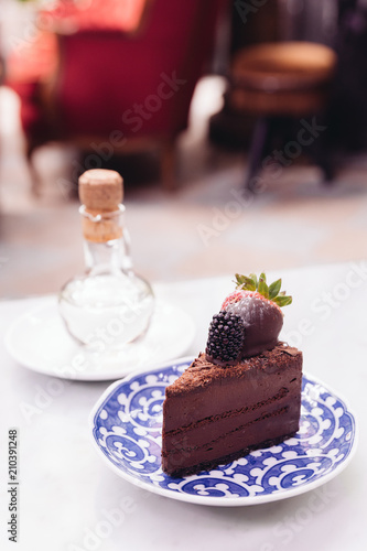 Slice of chocolate cheesecake topping with fresh strawberry and blackberry. 