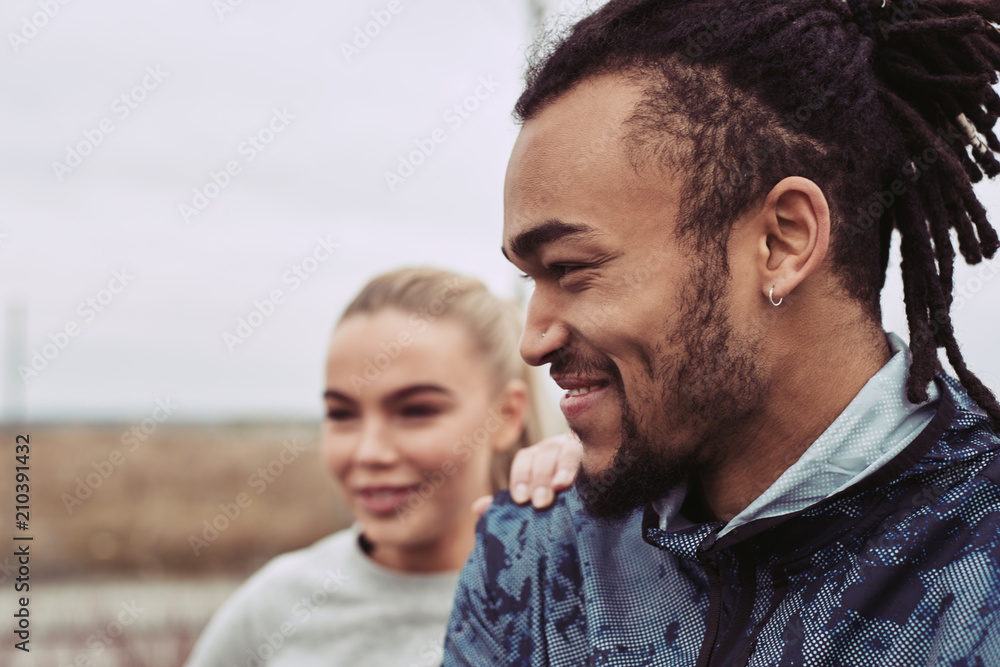 Smiling young couple preparing for a run outdoors together