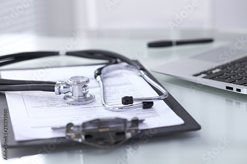 Wallpaper Mural Stethoscope lying at the desk with medical history records and laptop computer. Medicine doctor's working table concept Torontodigital.ca