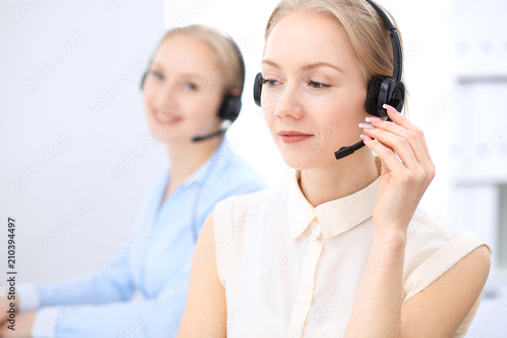 Bright call center office. Two blonde women in a headset Bright call center office. Two blonde women in a headset