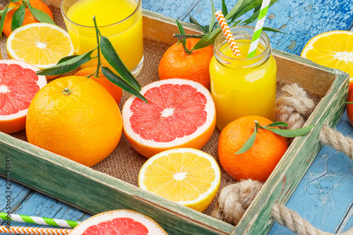 Fototapeta Naklejka Na Ścianę i Meble -  Different fruits and glass with fresh orange juice, wooden background