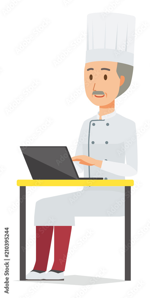 An elderly male chef wearing a cook coat is operating a laptop computer