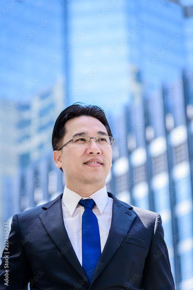 The asian businessman has thinking of vision with building and city background. The asian businessman has thinking of vision with building and city background.