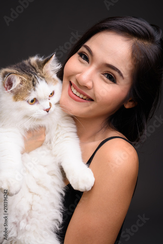 Young beautiful Asian woman holding Persian cat