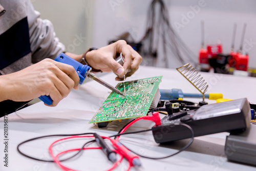 Wallpaper Mural Close up of the hand men hold tool repairs electronics manufacturing Services,Repair of electronic devices, tin soldering parts. Torontodigital.ca