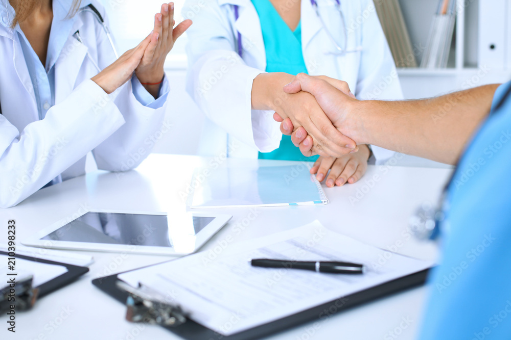 Two doctors shaking hands to each other at meeting. Teamwork and agreement in medicine Two doctors shaking hands to each other at meeting. Teamwork and agreement in medicine