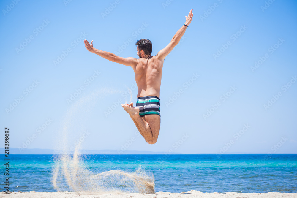 Happy traveler jumping happy at the beach, summer holiday Happy traveler jumping happy at the beach, summer holiday
