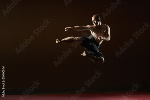 Adult sportsman trains a kick in a jump