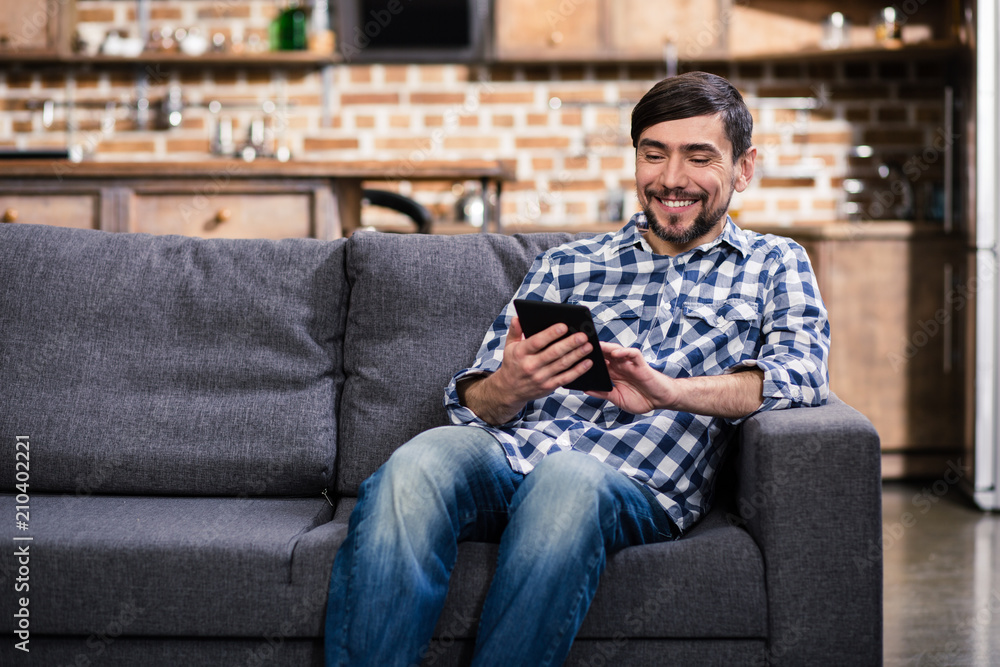 Positive bearded man reading an e book Positive bearded man reading an e book