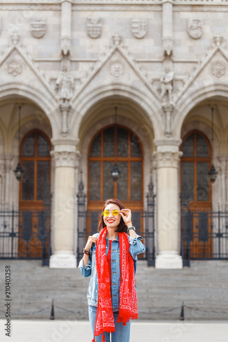 Happy asian casual woman student enjoying great view of the Parliament building in Budapest city, travel in Europe concept © EdNurg