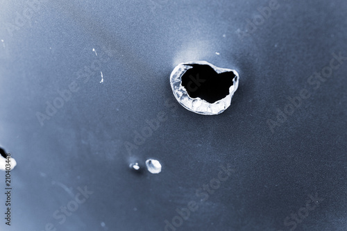 bullet hole in armored metal plate, war conflict and military tragedy concept photo
