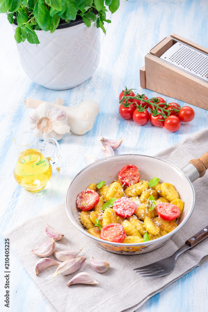 gnocchi baked with green pesto, cherry tomatoes and parmesan