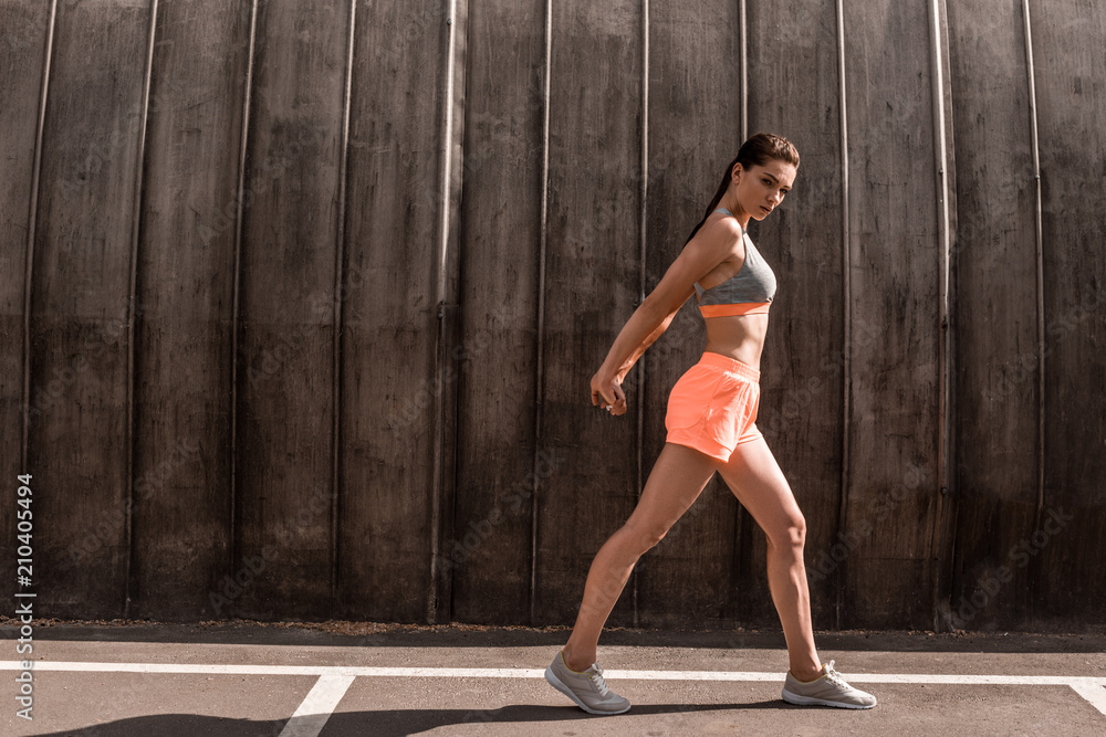 Fototapeta premium beautiful athletic woman exercising on parking