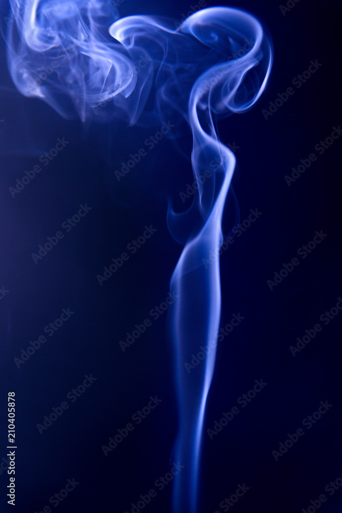 Texture of blue smoke on a black background, similar to figure of a woman with long hair developing in the wind.
