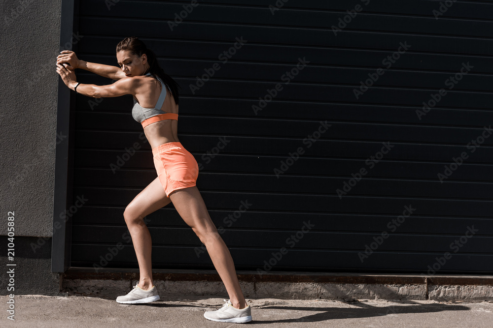 Fototapeta premium attractive sportswoman training in sportswear in city