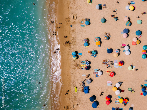 Aerial View From Flying Drone Of People Crowd Relaxing On Algarve Beach In Portugal