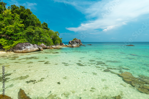 Jungle borders the beautiful sandy beaches, with big stones in the water, on Tioman Island, Malaysia