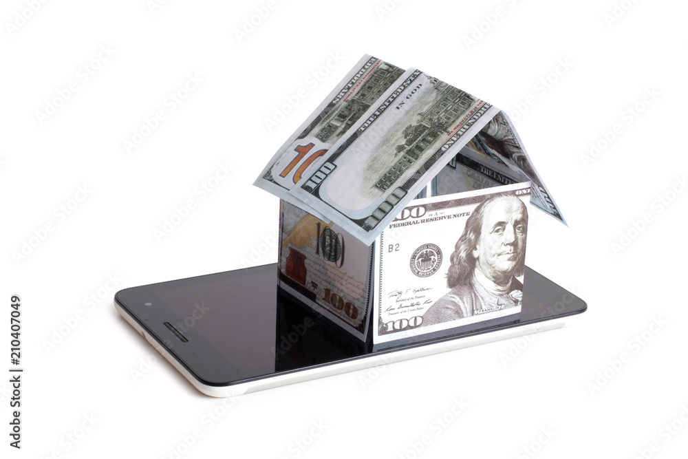 Paper house made of banknotes on a tablet on a white background Paper house made of banknotes on a tablet on a white background