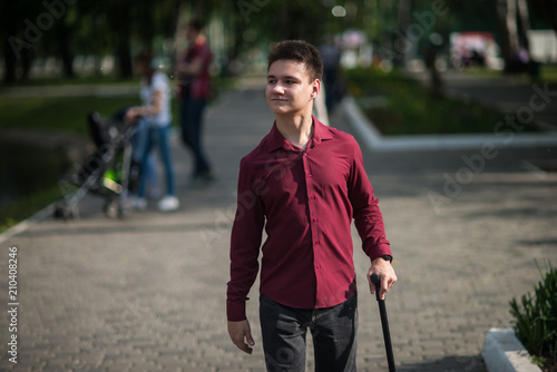 Young man walking with a cane in his hand