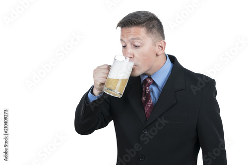 Young businessman in suit drinking beer from mug, isolated on white background © Gribanov