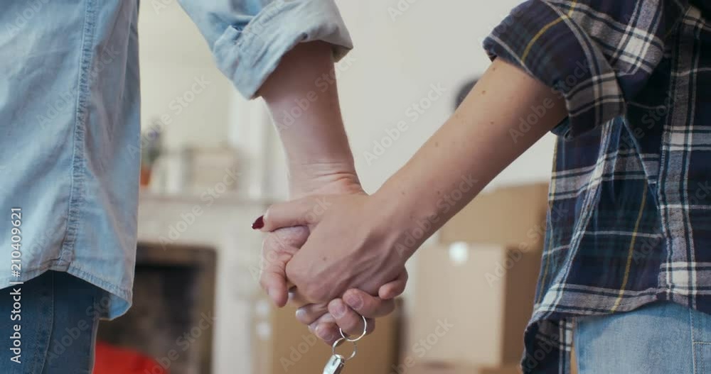 Hands of newlyweds hold on each other and keys Hands of newlyweds hold on each other and keys