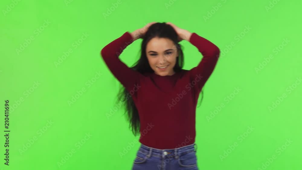 Gorgeous young happy woman smiling cheerfully playing with her hair, posing on green background. Attractive young joyful woman posing playfully at studio. Teenage, lifestyle, healthy hair. Gorgeous young happy woman smiling cheerfully playing with her hair, posing on green background. Attractive young joyful woman posing playfully at studio. Teenage, lifestyle, healthy hair.
