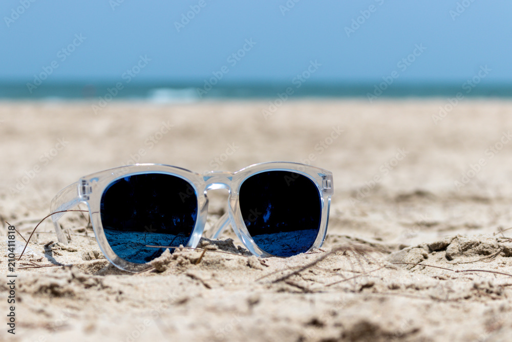 Sun glasses with transparent cover on the sand beach