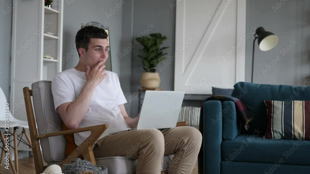 Casual Sitting Man in Shock while Working on Laptop Casual Sitting Man in Shock while Working on Laptop