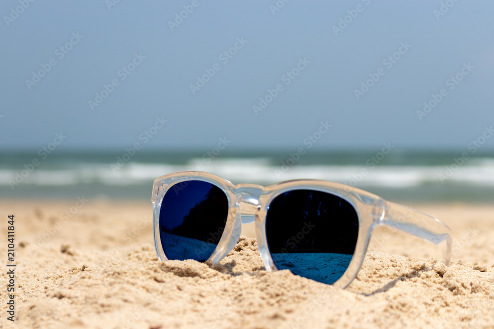 Sun glasses with transparent cover on the sand beach