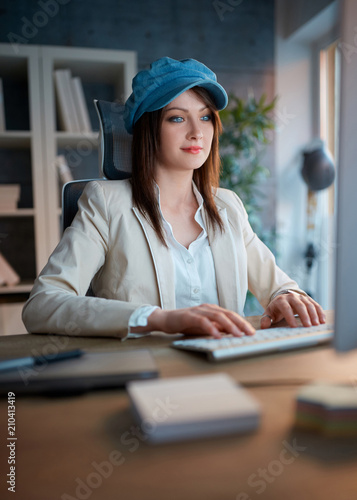 Graphic designers at work - woman working late on computer at office.