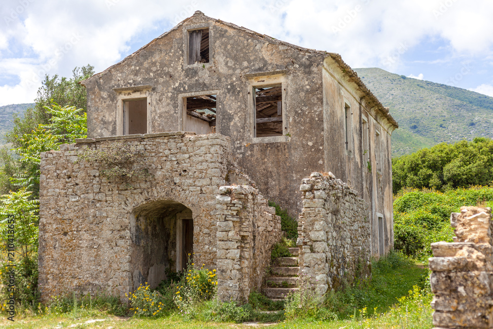 Ancient house built with concrete. Flowering plants growing in the ground. Wooden blocks falling from the ceiling. Ruins during medieval era. History travel. Ancient house built with concrete. Flowering plants growing in the ground. Wooden blocks falling from the ceiling. Ruins during medieval era. History travel.