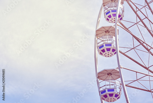 Retro toned picture of a Ferris wheel in an amusement park.