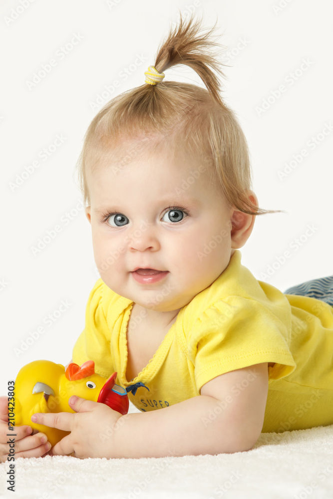 Studio portrait of adorable baby girl wearing pink hat and playing with yellow rubber duck, isolated on the white background Studio portrait of adorable baby girl wearing pink hat and playing with yellow rubber duck, isolated on the white background