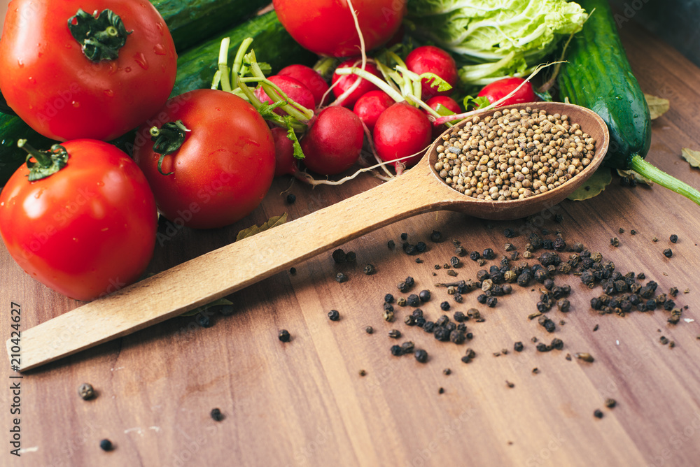 Fresh vegetables tomatoes, cucumbers, and spices on wooden background. Copy space Fresh vegetables tomatoes, cucumbers, and spices on wooden background. Copy space