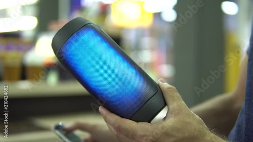 Portable speaker glows in hand.