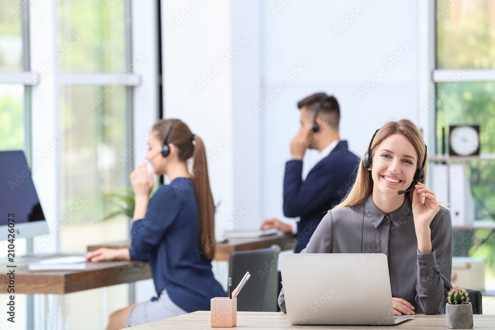 Female receptionist with headset at desk in office Female receptionist with headset at desk in office