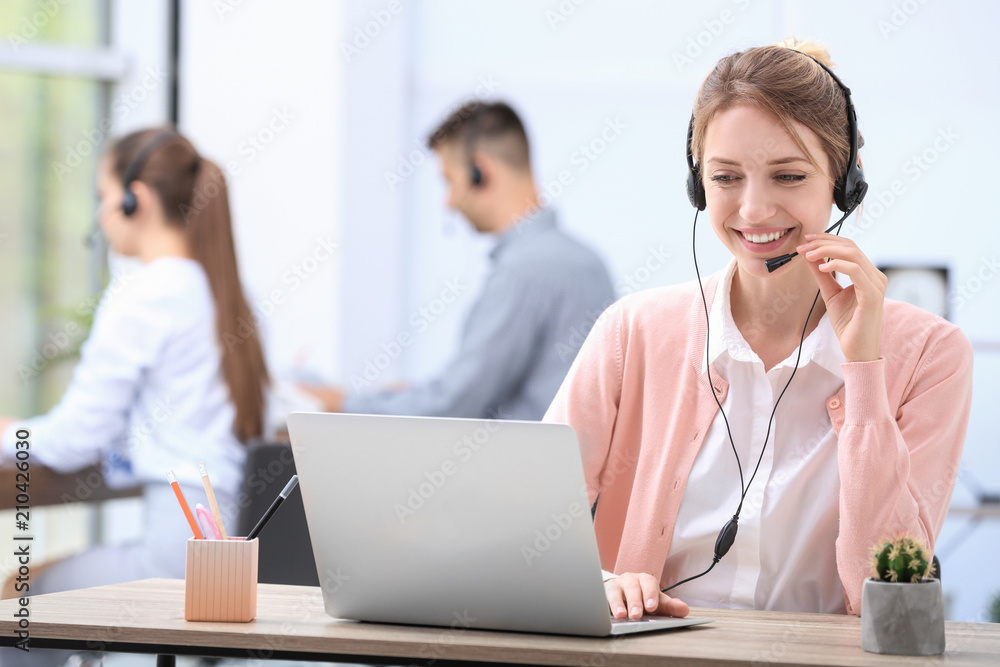 Female receptionist with headset at desk in office Female receptionist with headset at desk in office