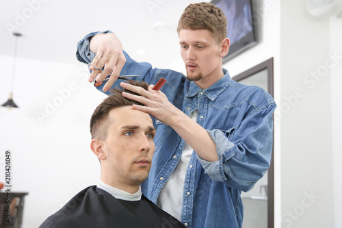 Professional barber working with client in hairdressing salon. Hipster fashion