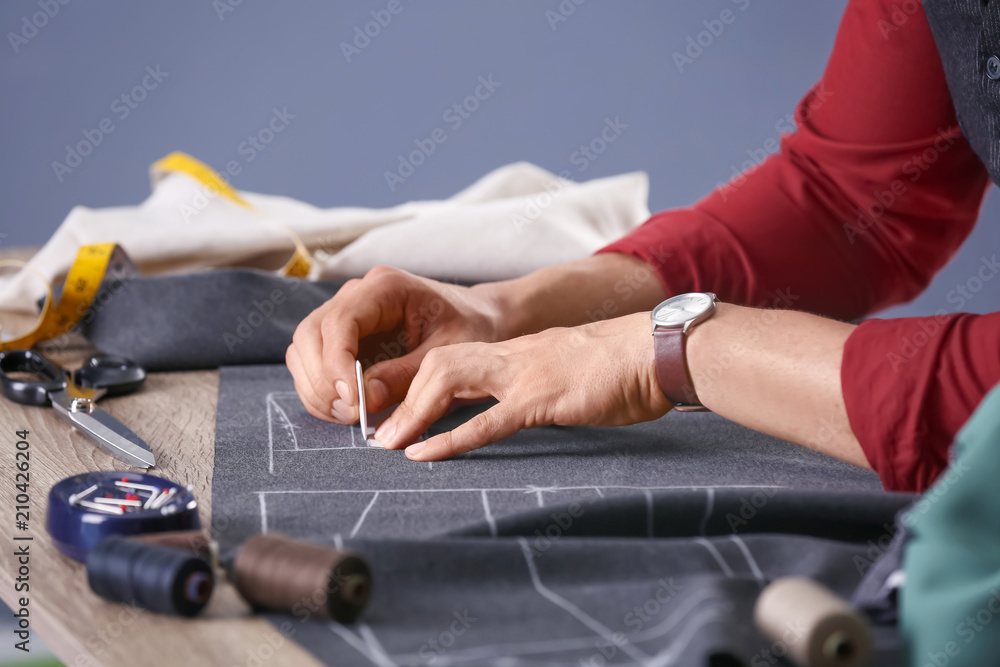 Tailor working at table in atelier, closeup